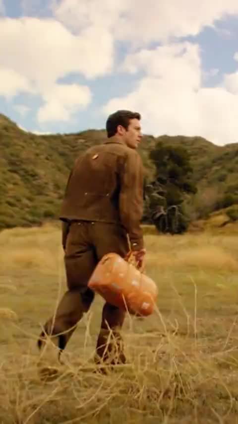 Generated cinematic scene, a man crossing a field carrying bread